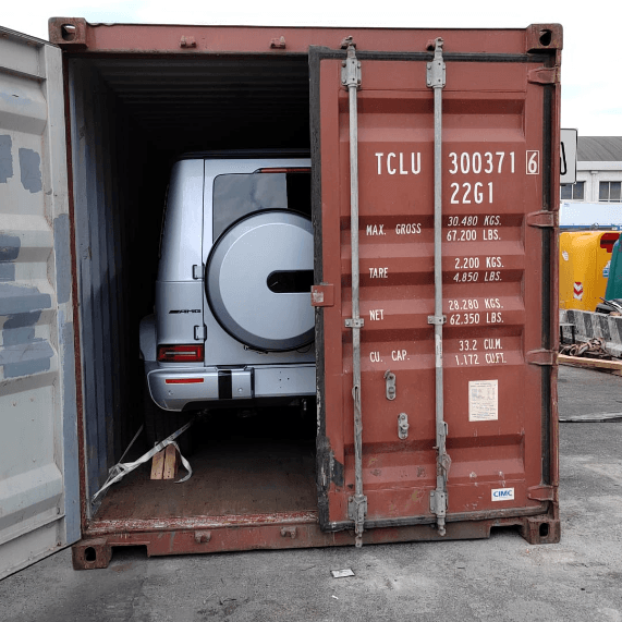 Furgone bianco caricato all'interno di un container di spedizione rosso